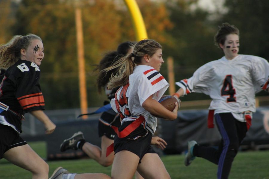 Sophomores and seniors run with the ball in this Powder Puff game.  Seniors won this years game. Photo by Lajla Raske