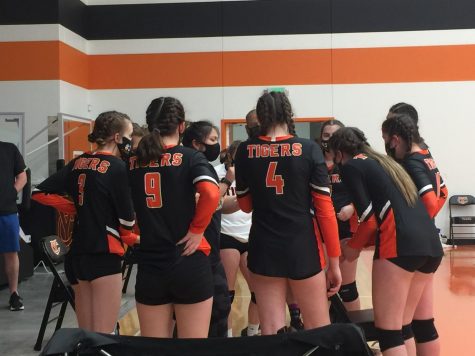 The YC girls volleyball team huddle up during a game. These huddle up times are often good times of communication, showing how the team works well together!