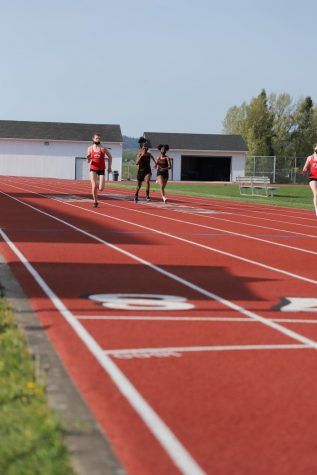 Some track athletes practicing on the track. 