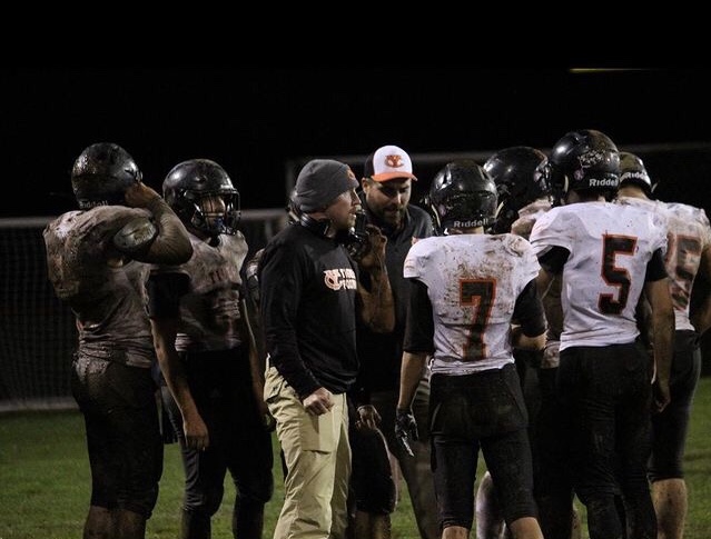 Coach Brad McKechnie huddles with his team. 