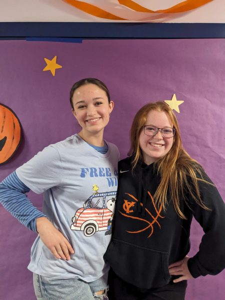 AvaLina Rigamonti and Madison Guinn stand together in the seniors Charlie Brown themed hallway.